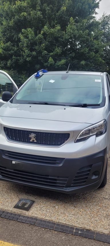 A silver van with a new windscreen parked on the road, completed by Epic Windscreens Mobile Fleet replacement services