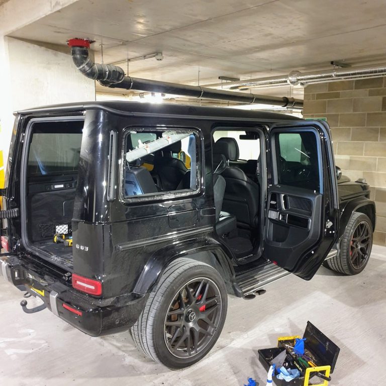 A black Mercedes G-Class parked in a garage, emphasizing its elegance while preparing for a rear quarter window replacement service